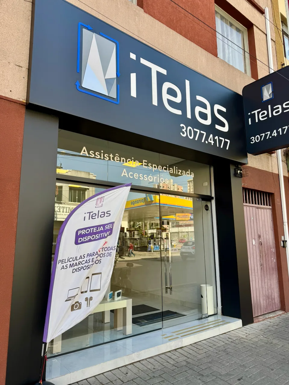 Fachada da loja iTelas em Curitiba, com letreiro e vitrine na Rua João Negrão