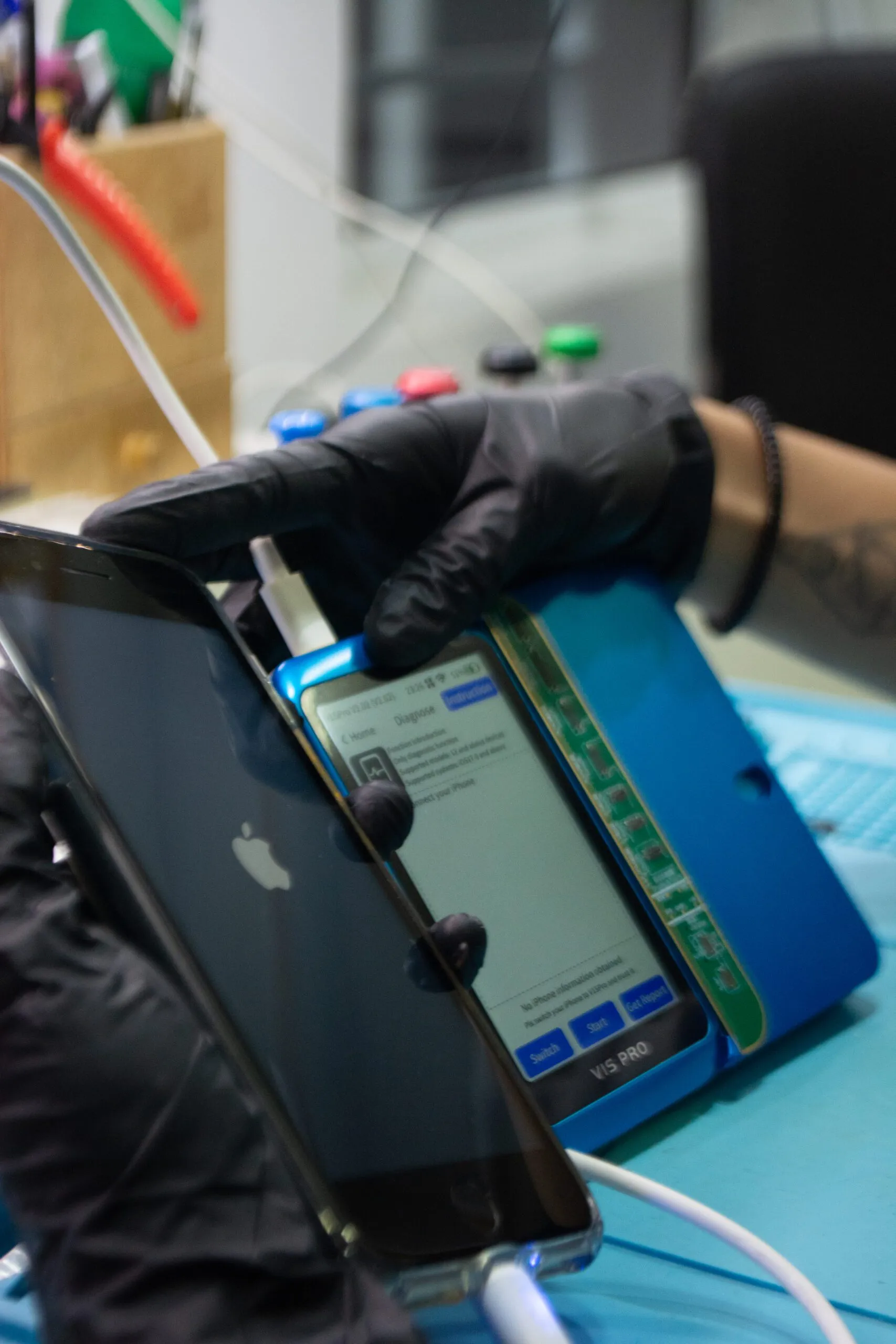 Tecnica realizando diagnostico em iPhone na bancada da iTelas