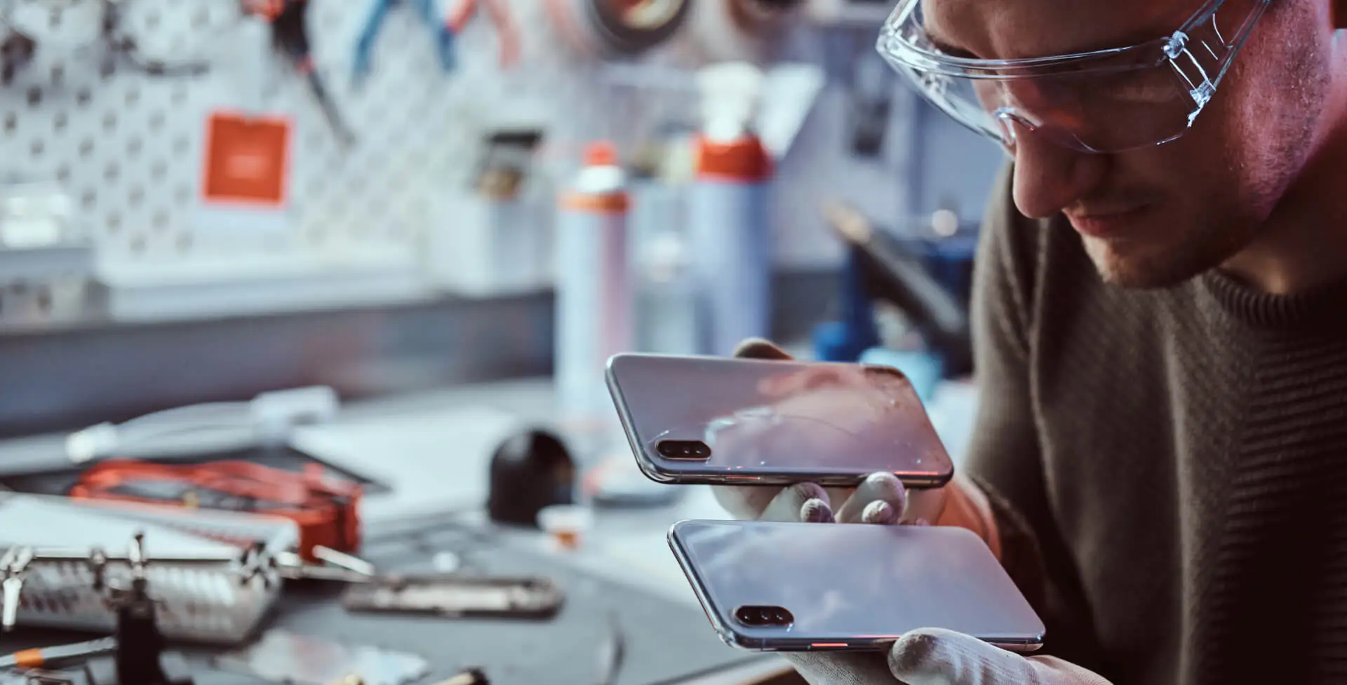 Tecnico comparando dois smartphones durante avaliacao de componentes